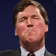 Illustration for article titled Tucker Carlson Says QAnon-ified Capitol Rioters Aren't Terrorists, They're 'Gentle People Waving American Flags'